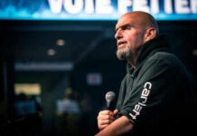 Man speaking into microphone on stage.