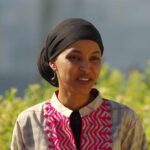 Omar’s Guest Causes Chaos at SOTU A woman in traditional attire smiling outdoors