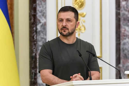 2521850327 Man speaking at podium with microphones, Ukrainian flag behind.