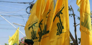 Men in military attire with yellow flags outdoors