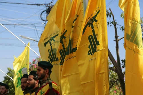 hezbollah2379767211 Men in military attire with yellow flags outdoors