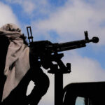 IRAN BEGS For Help — Houthis VANISH Silhouette of an armed individual with a mounted weapon against a cloudy sky
