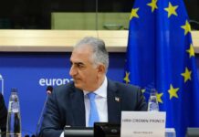 Exiled Crown Prince’s Call: Is Iran’s Collapse Imminent? Crown Prince Reza Pahlavi attending a political meeting in front of the EU flag