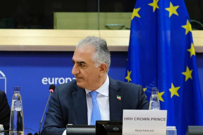 shutterstock_2269011913.jpg Crown Prince Reza Pahlavi attending a political meeting in front of the EU flag