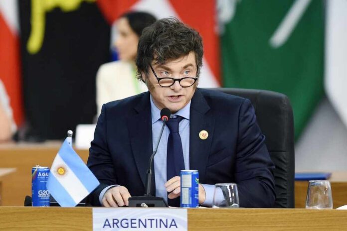 A government official from Argentina speaking at a conference with flags in the background