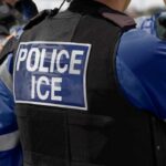 County Blocks ICE Access—Radical Power Play Close-up of a police officer's vest with 'POLICE ICE' label