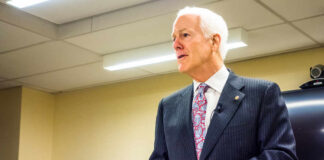 A man in a suit delivering a speech in a conference room