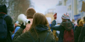 Person holding megaphone at outdoor protest or rally