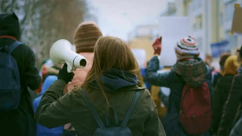 student-march2381674931 Person holding megaphone at outdoor protest or rally