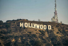Hollywood sign with communication tower on hillside.
