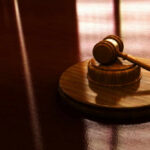 Judge STOPS Trump’s College Admissions Crackdown Gavel on a wooden table in sunlight