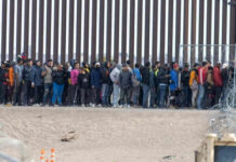 Mass Amnesty OUTRAGE: GOP Divided Over Immigration Large group of people standing near border fence