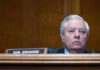 Man sitting at a desk with nameplate Sen Graham