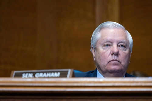 Man sitting at a desk with nameplate Sen Graham