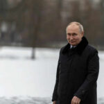 Person in dark coat standing on snowcovered ground
