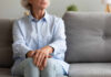 Elderly woman sitting on a couch with a thoughtful expression