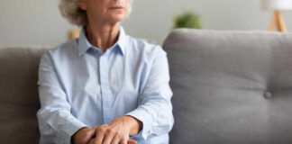 Elderly woman sitting on a couch with a thoughtful expression