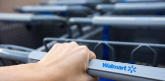 Hand gripping a Walmart shopping cart handle