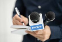 A journalist holding a notebook and microphones labeled 'NEWS'