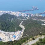 Ukrainian Drones Ignite Chaos at Russian Oil Hub Aerial view of an industrial oil terminal by the coast surrounded by hills