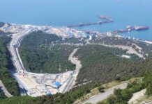 Aerial view of an industrial oil terminal by the coast surrounded by hills