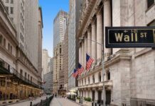 View of Wall Street with skyscrapers and American flags