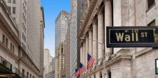 View of Wall Street with skyscrapers and American flags