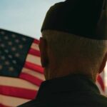 Veterans’ Lifeline: Psychedelics in the Spotlight A veteran in uniform standing in front of an American flag at sunset