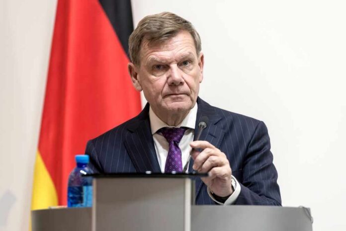 A man in a suit speaking at a podium with a microphone