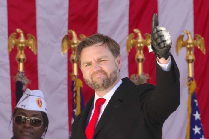 Man in formal attire giving a thumbs-up gesture at a public event