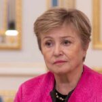 IMF WARNS: Ceasefire Won’t Fix Economic Damage A woman in a pink jacket with a serious expression, seated in a formal interior