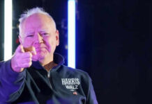 Man pointing with neon lights behind him