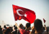 Person waving Turkish flag in a crowd