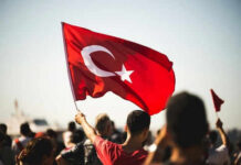 Person waving Turkish flag in a crowd