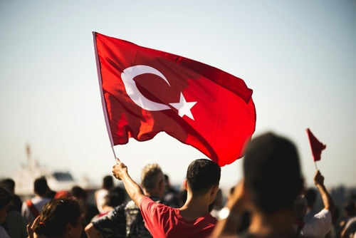 Person waving Turkish flag in a crowd
