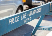 NIGHT EXIT: Group Climbs Out of Brooklyn Sewer in Strange Scene Blue NYPD barricade with Police Line - Do Not Cross.
