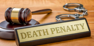 Death penalty sign with judge's gavel and handcuffs on wooden desk