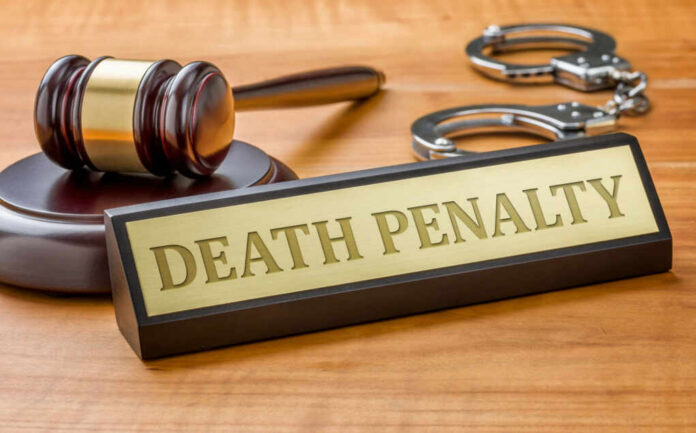 Death penalty sign with judge's gavel and handcuffs on wooden desk