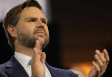 Billion-Dollar Freeze—Vance Sparks CHAOS! Person clapping enthusiastically in formal attire