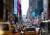 Manhattan’s Housing Crisis – Middle-Class DOOMED! Busy city street with taxis and billboards daytime