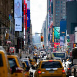 Busy city street with taxis and billboards daytime