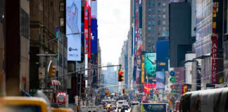 Busy city street with taxis and billboards daytime