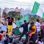 ISIS Leader Annihilation: U.S-Nigeria Strike Stuns Crowd at a rally waving a large Nigerian flag