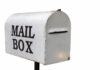 Gen Z Revives Snail Mail—Digital Detox Postal worker loading mail into a blue USPS collection box