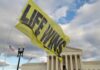 Oklahoma’s SHOCK Move: Chemical Abortion Traffickers Targeted A large yellow flag with the words 'LIFE WINS' waving in front of the Supreme Court building