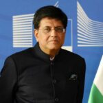 Trade Wins Over Tragedy: Canada–India’s Shocking Shift A man in a suit speaking at a podium with a microphone
