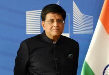 Trade Wins Over Tragedy: Canada–India’s Shocking Shift A man in a suit speaking at a podium with a microphone