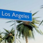 Sign indicating Los Angeles surrounded by palm trees