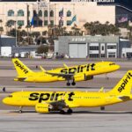 Two Spirit Airlines planes on a runway at an airport