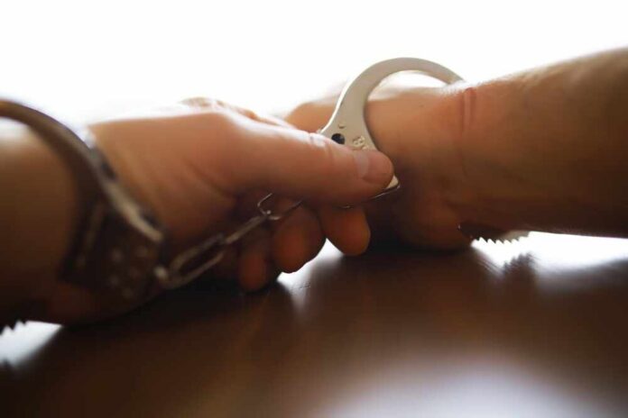 Police,Officer,Handcuffing,A,Suspect,-,Close-up,Of,Hand,And Close-up of a handcuff being secured on a wrist